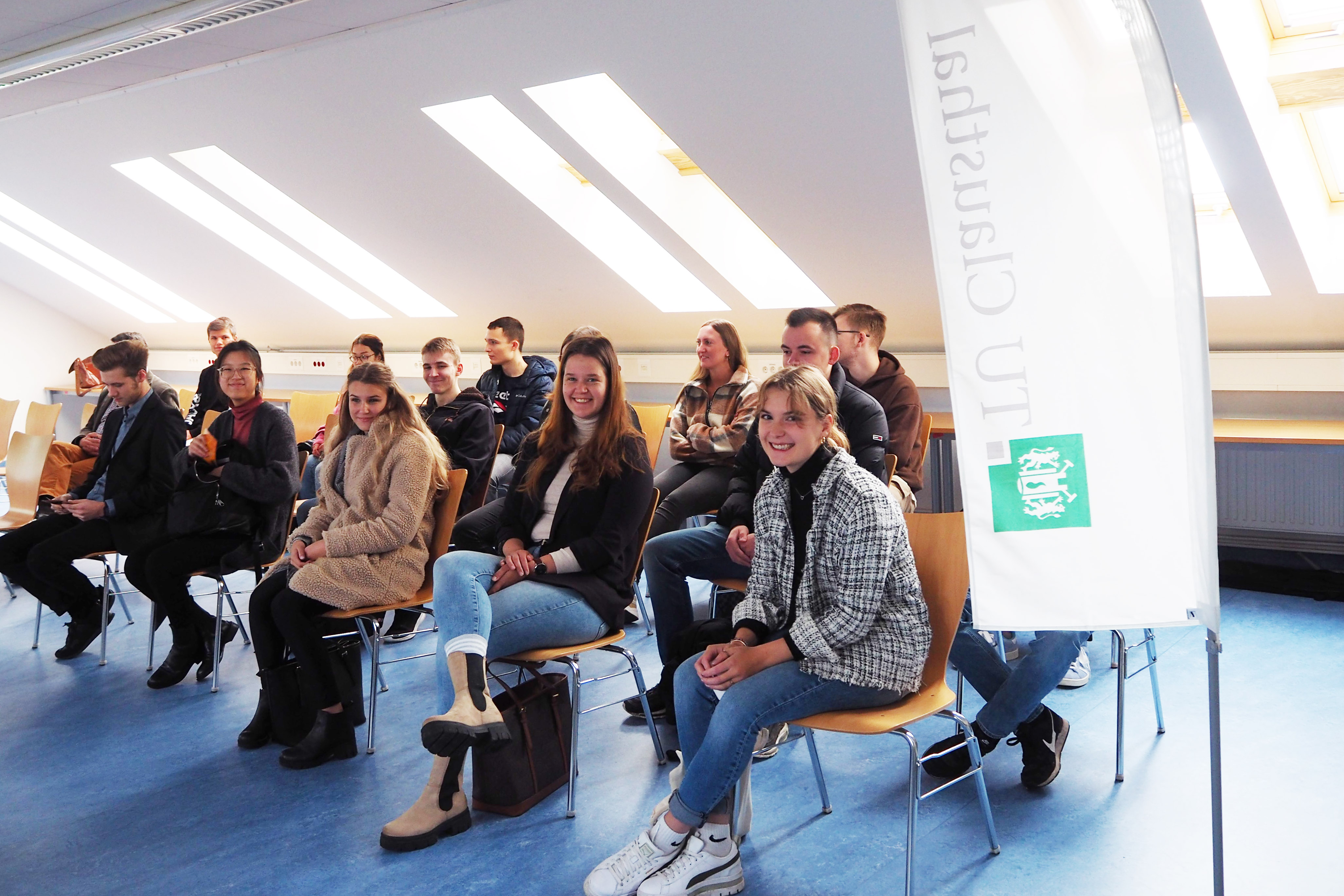 Menschen in einem Raum hören einer Präsentation zu