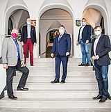 Menschen mit Masken stehen auf einer Treppe