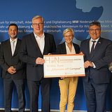 Personen mit einem Scheck der Hochschule.digital Niedersachsen