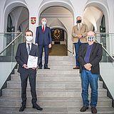 Vier Personen stehen auf einer Treppe