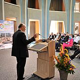 Person an einem Rednerpult hält eine Präsentation