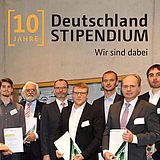 Menschen stehen neben einem kleinen Stand und Blumen