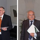 Personen halten ein Dokument in der Hand und stehen nebeneinander