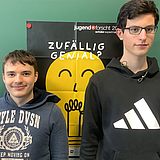 Zwei Personen stehen vor einem "Jugend forscht"-Plakat