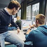 Zwei Personen betrachten ein Diagramm auf dem Monitor