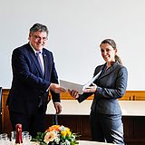 Zwei Personen halten ein Dokument in der Hand