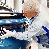 Person arbeitet am Fließband von VW